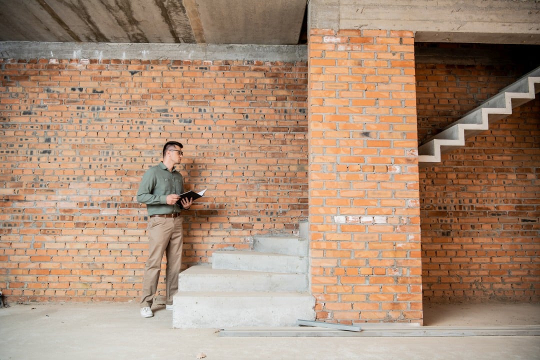 Professional environmental specialist performing mold inspection and air quality testing in home